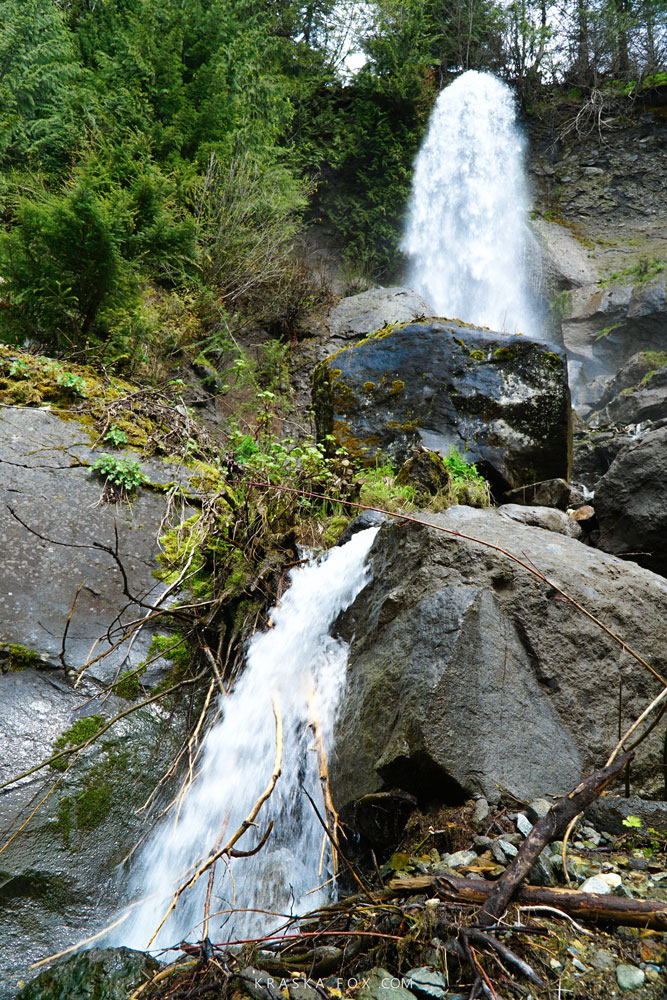 Beautiful keyhole hot springs trail scenery - waterfalls cascading down the cliff along side the trail, British Colombia.