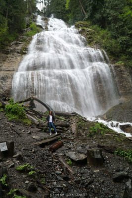 Alicja standing at the base of the falls zoomed out.