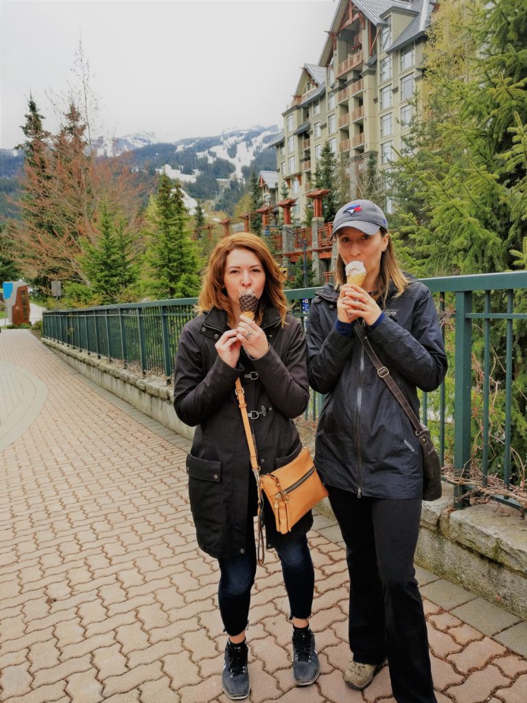 A view of the mountain in the back and a friend and myself enjoying ice cream in the foreground.